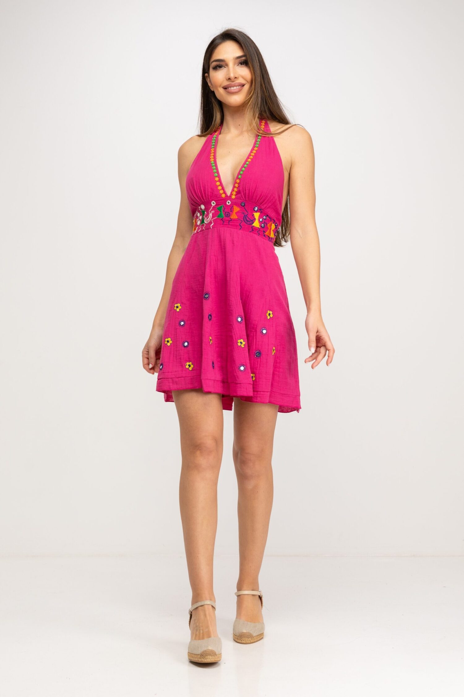 VESTIDO CORTO,  FALDA DE VUELO Y CORTE BAJO EL PECHO CON BORDADOS DE INSPIRACION ETNICA Y DETALLES DE FLORES EN LA FALDA. CON TIRANTES PARA ATAR EN EL CUELLO, CIERRE TRASERO CON CREMALLERA INVISIBLE Y GOMA AJUSTBLE EN ESPALDA