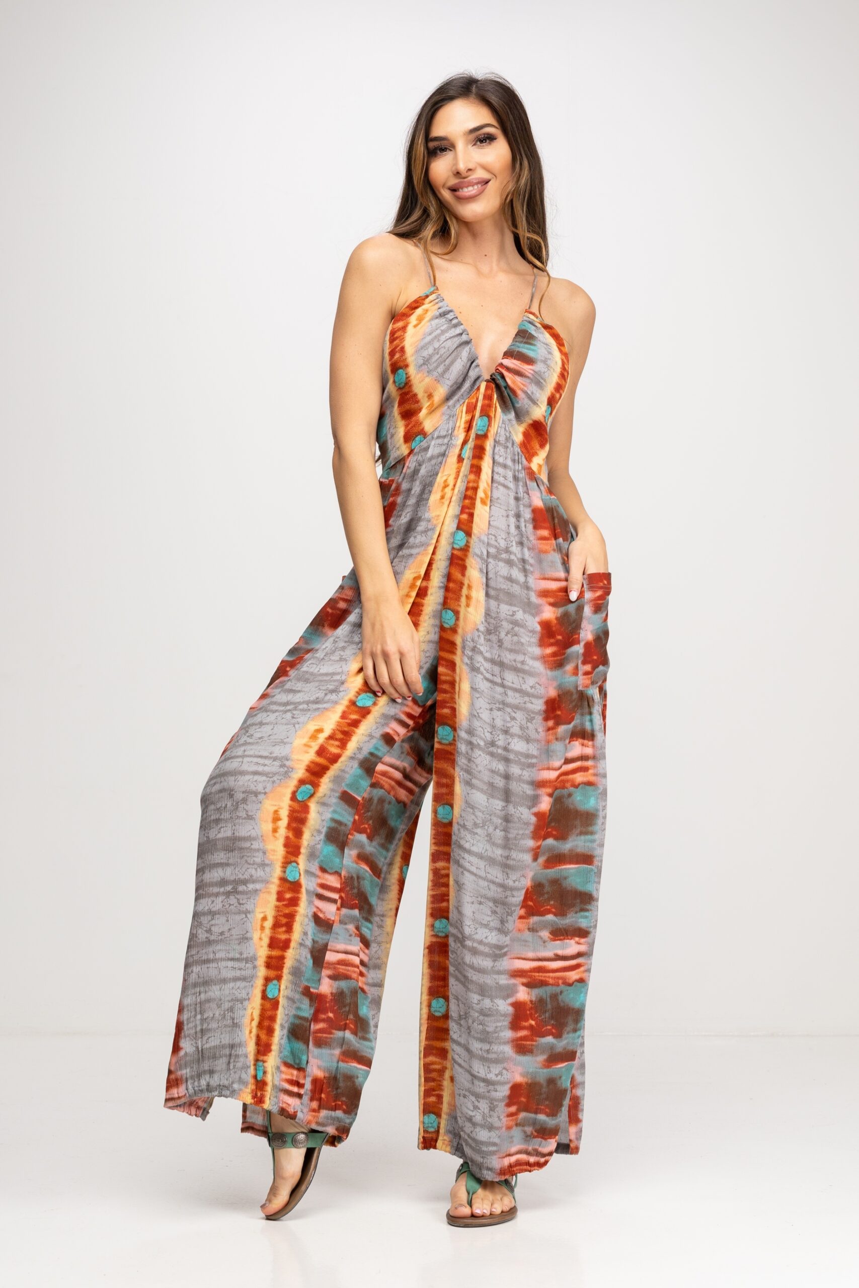 MONO TIE DYE CON TIRANTE ESPAGUETI QUE SALE DESDE EL CENTRO DEL ESCOTE PARA FRUNCIR LA FORMA DEL PECHO Y LLEGAN HASTA LA ESPALDA PARA AJUSTAR.EL PANTALON LLEVA DOS BOLSILLOS EN PARTE DELANTERA Y EL BAJO TIPO BOMBACHO CON PEQUEÑA ABERTURA